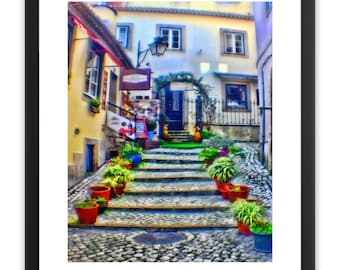 Pode incluir: Uma rua estreita de paralelepípedos numa cidade europeia com um conjunto de escadas que levam a uma porta. As escadas são ladeadas por plantas em vasos em vários tons de verde, vermelho e amarelo. A porta é emoldurada por um arco de pedra e um portão de ferro forjado.