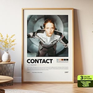 Peut inclure: Affiche encadrée du film "Contact" avec une femme en combinaison spatiale. Le poster a une bordure beige et le titre "CONTACT" en blanc. L'année 1997 est également affichée sur l'affiche.