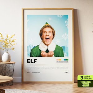 May include: A framed movie poster for the film "Elf" featuring a portrait of the main character with an open mouth. The poster has a light blue background with snowflakes and the title "ELF" in large white letters. The poster is in a wooden frame.