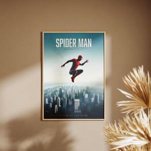 May include: A movie poster for Spider-Man: No Way Home featuring a red and blue Spider-Man suit with a black spider logo. The poster has a blue background with a cityscape in the background. The text "Spider-Man" is in white letters at the top of the poster.