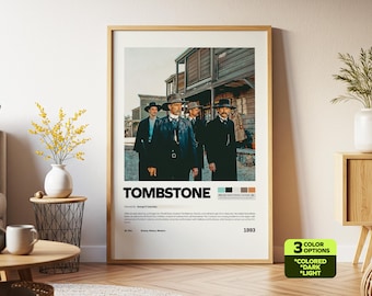 May include: A framed poster featuring the movie "Tombstone" with a Western theme. The poster shows four men in suits and hats, standing in front of a wooden building. The poster has a neutral color palette and includes the movie title and year.