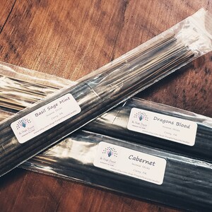 May include: Three packages of incense sticks with labels that read "Basil Sage Mint", "Dragons Blood", and "Cabernet".