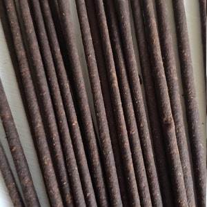 May include: A bundle of brown incense sticks, arranged in a fan shape. The sticks are approximately 25 cm long and have a rough, textured surface.