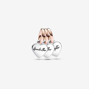May include: Three silver heart-shaped charms with rose gold accents. Each charm has a cursive inscription: "Grandmother", "her", and "daughter". The charms are connected by rose gold loops.