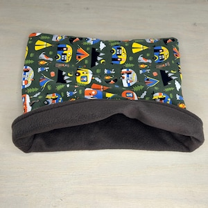 May include: A brown and green pet bed with a camping themed print. The bed is made of soft fleece and has a cozy, cave-like design.