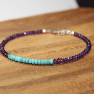 May include: A delicate bracelet made with amethyst and turquoise beads. The bracelet is silver toned and has a simple clasp.