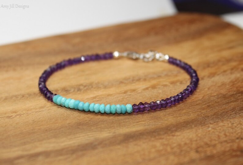 May include: A delicate bracelet made with amethyst and turquoise beads. The bracelet is silver toned and has a simple clasp.