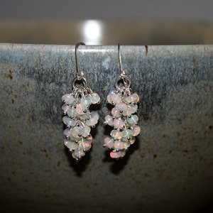 Peut inclure: Une paire de boucles d'oreilles en argent avec un groupe de pierres d'opale blanches suspendues &agrave; chaque boucle d'oreille.