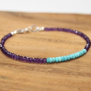May include: A delicate bracelet made with small amethyst and turquoise beads. The bracelet is silver toned and has a clasp closure.