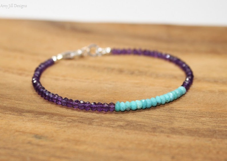 May include: A delicate bracelet made with small amethyst and turquoise beads. The bracelet is silver toned and has a clasp closure.