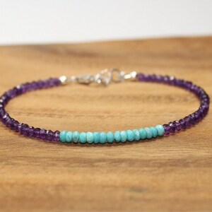 May include: A delicate bracelet made with small amethyst and turquoise beads. The bracelet is silver toned and has a simple clasp.