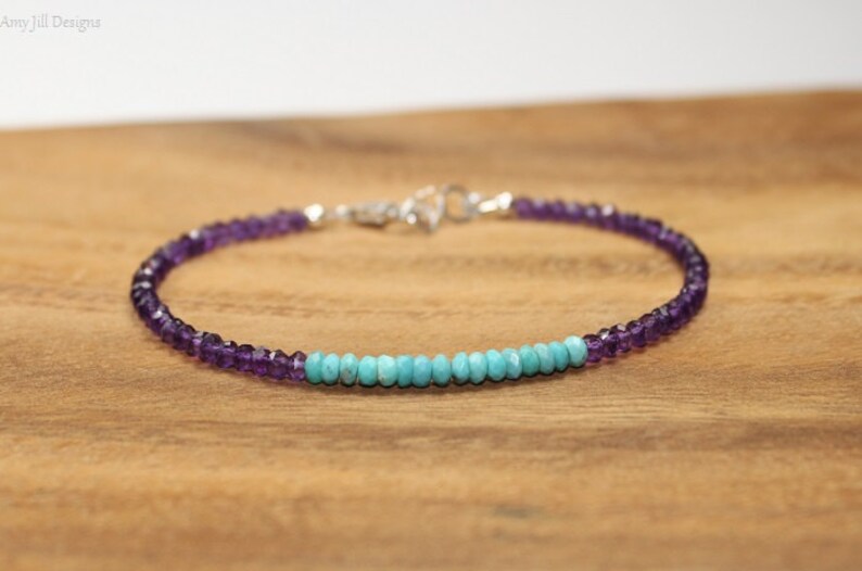 May include: A delicate bracelet made with small amethyst and turquoise beads. The bracelet is silver toned and has a simple clasp.
