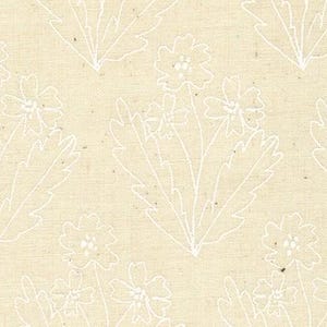 May include: A beige fabric with a white floral pattern. The flowers are stylized and have a simple design.