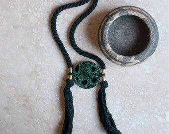 Vintage ‘Luna Morvah' forest green & black speckled stoneware with brass pendant on long black twisted cotton rope.