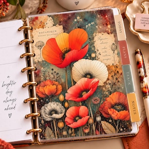 May include: A disc-bound planner featuring a floral divider with red, orange, and white poppy illustrations, text reading "BOTANIQUE FLEURS SAUVAGES" and "Papaver rhoeas", and tabbed sections labeled "TODAY", "PLANS", "TRACK", and "NOTES" with a pen nearby.