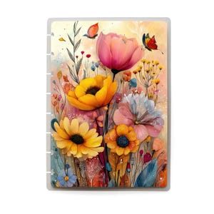 May include: A planner cover with a floral design. The artwork depicts a variety of colourful flowers, including yellow sunflowers, orange poppies, and pink tulips, with butterflies. The background has a soft, watercolour effect. The planner has a clear, plastic cover.
