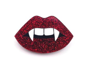 Könnte beinhalten: Rote Glitzer-Vampirlippen mit weißen Zähnen.