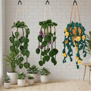 May include: Three hanging crochet planters with trailing green leaves and flowers. The planters are suspended from black hooks against a white brick wall. Several potted plants in white pots are arranged on the floor.