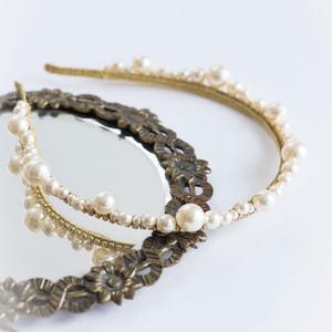 Large pearl headband with curved tiara silhouette.