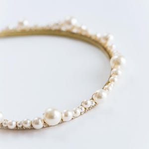 Large pearl headband with curved tiara silhouette.