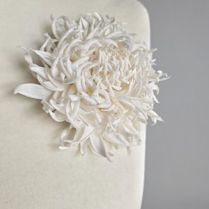 Chrysanthemum silk flower worn on mannequin as brooch