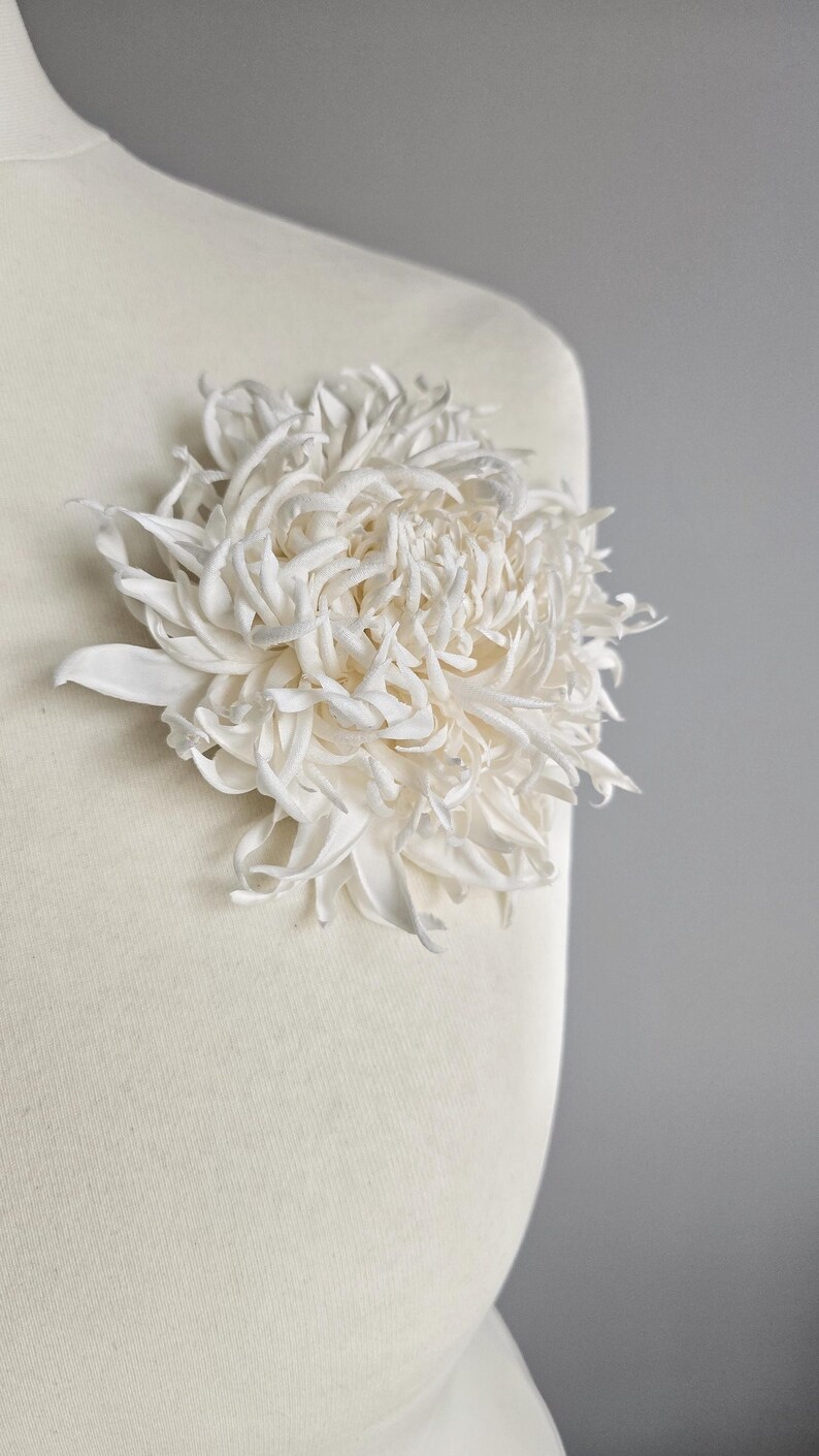 Chrysanthemum silk flower worn on mannequin as brooch