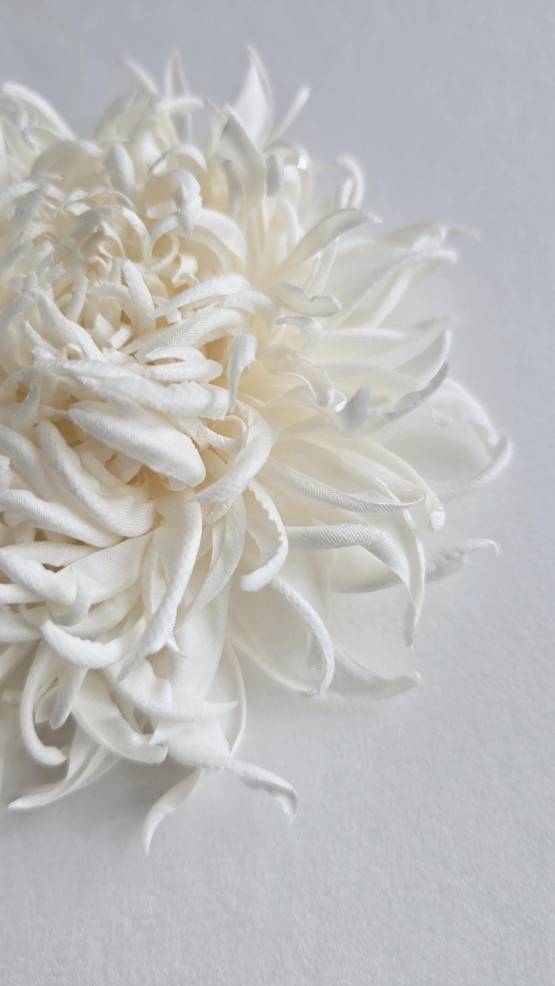 Close-up of handmade silk chrysanthemum petals shaped with millinery tools