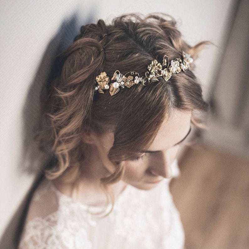 Gold bridal headband worn by bride, brass flowers motif and pearl accents, understated bridal hair accessory