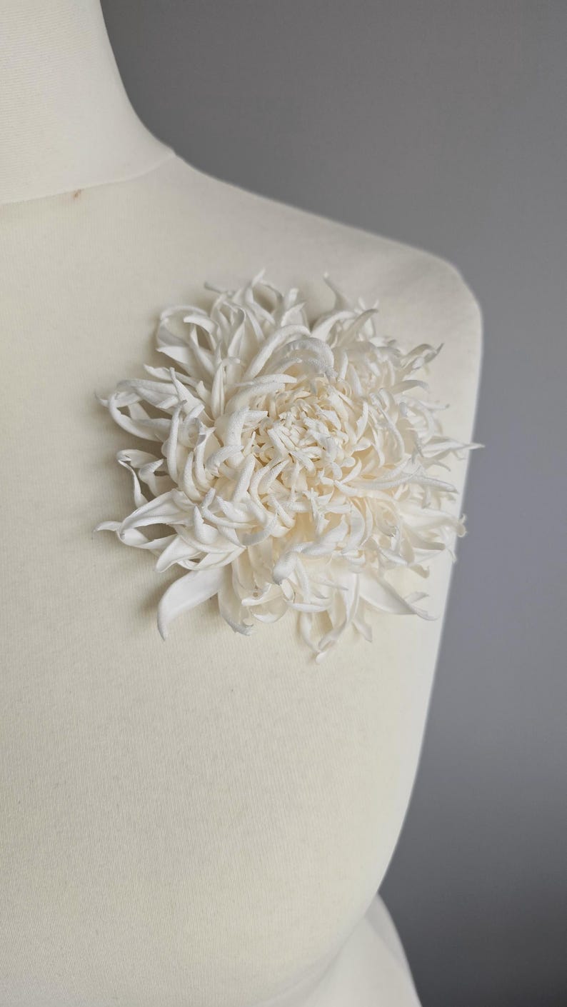 Chrysanthemum silk flower worn on mannequin as brooch