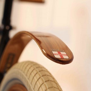 Teak rear wood bicycle fender finished with Marine Spar Polyurethane finish with stainless hardware.  Mounts to the rear brake bolt hole.