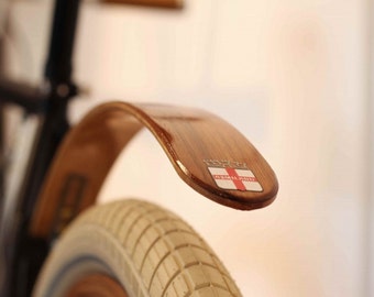 Teak rear wood bicycle fender finished with Marine Spar Polyurethane finish with stainless hardware.  Mounts to the rear brake bolt hole.