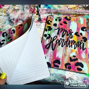 May include: A colorful notebook with a leopard print and abstract paint design. The cover says "Mrs. Hardeman".