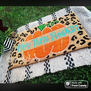 May include: A brown doormat with a black leopard print design features a large orange pumpkin with a green stem and the text "Hey There Pumpkin" written in turquoise.