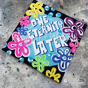 May include: A black and blue background with the text "...ONE ETERNITY LATER" in white. The background is decorated with colorful flowers in pink, yellow, green, and purple.