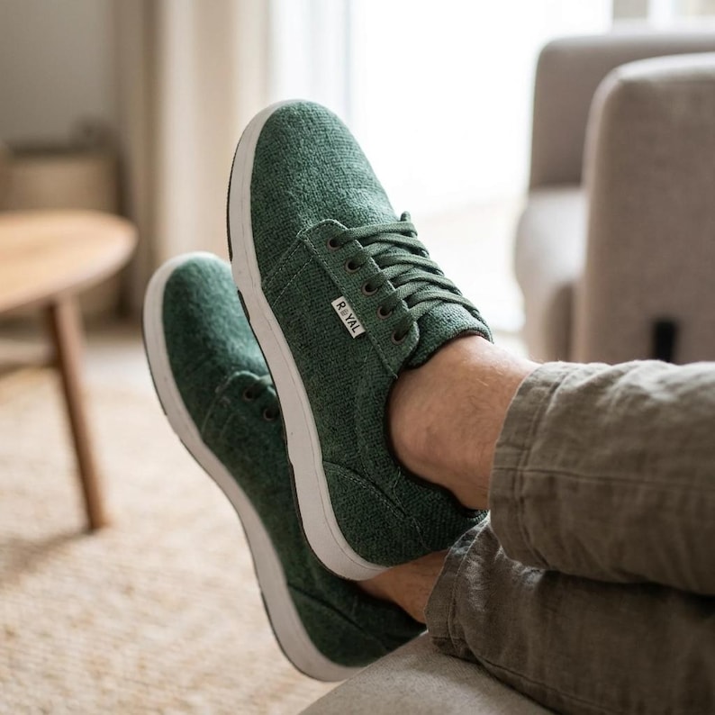 May include: Green canvas sneakers with white soles and laces. The shoes have a low-profile design and the word "ROYAL" is printed on the side. The sneakers are shown in a relaxed setting.