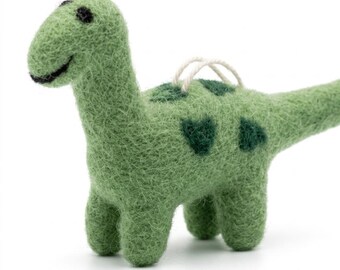 May include: A light green felted wool dinosaur figurine with a long neck and tail. The dinosaur features dark green spots along its back and sides, black felted eyes, and a small white string loop attached to the top for hanging purposes.