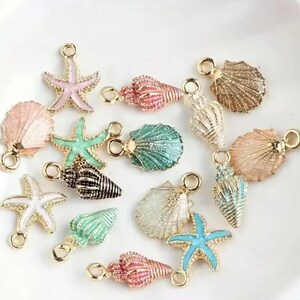 May include: Assortment of gold-tone metal charms featuring seashells and starfish in various colours, including pink, green, blue, and white.