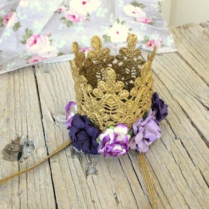 Può includere: Fascia per capelli con corona dorata glitterata e fiori in tessuto viola e lavanda.