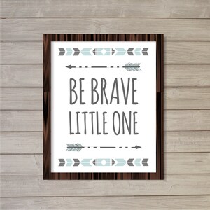 May include: A framed print with a white background and a gray and blue geometric design. The print features the text "Be Brave Little One" in gray.