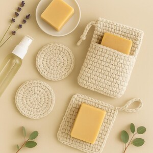 May include: A mini spa set with crocheted soap savers and scrubbies. The set includes two round scrubbies, a square soap saver with a handle, and a crocheted pouch with a bar of soap inside. The set is made with natural materials and is perfect for a relaxing spa experience at home.