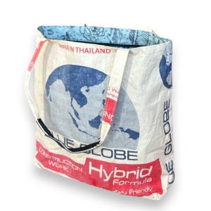May include: White tote bag with a blue globe graphic and red text that reads "Hybrid Formula". The bag has a blue floral patterned lining and the text "Made in Thailand".