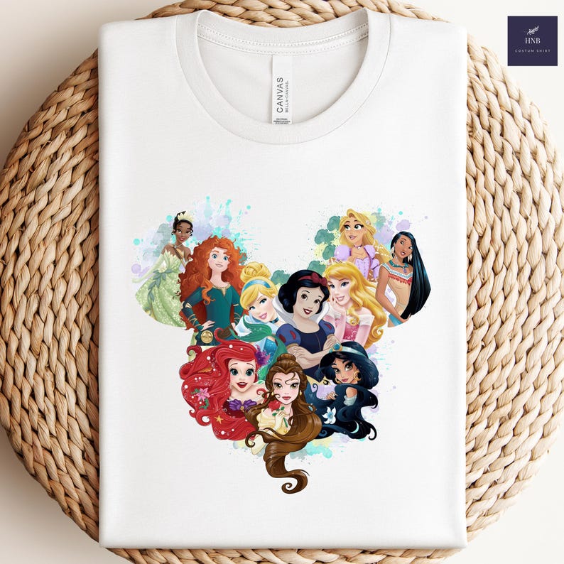 K&ouml;nnte beinhalten: Wei&szlig;es T-Shirt mit einem herzf&ouml;rmigen Design, das aus Illustrationen von Disney-Prinzessinnen besteht. Die Grafik zeigt verschiedene Prinzessinnen in leuchtenden Farben. Das T-Shirt ist aus weichem Material. Ein tolles Geschenk f&uuml;r Disney-Fans.