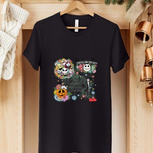 May include: Black t-shirt featuring a colorful graphic design with characters and text from "The Nightmare Before Christmas." The design includes Jack Skellington, Sally, and other characters, with the words "Trick or Treat?" and "This is Halloween."