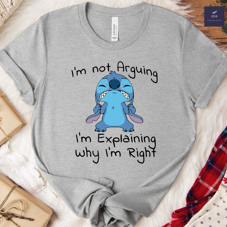 May include: A heather gray t-shirt featuring a cartoon image of Stitch with the text "I'm not Arguing, I'm Explaining why I'm Right." The blue Stitch character is in an angry pose. The shirt is made of a soft material.
