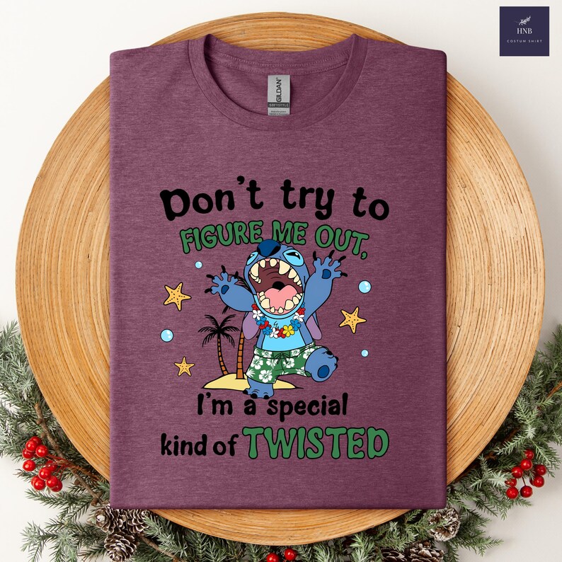 May include: A maroon t-shirt featuring a cartoon character with the text "Don't try to figure me out, I'm a special kind of twisted." The character is blue with a large mouth and is wearing a floral lei and shorts.