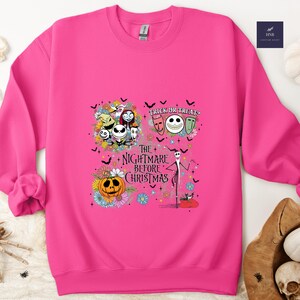 May include: A bright pink sweatshirt featuring a graphic from "The Nightmare Before Christmas." The design includes Jack Skellington, Sally, Zero, and other characters, along with the text "Trick or Treats" and "The Nightmare Before Christmas."