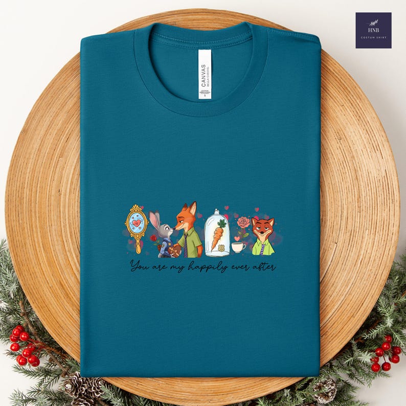 May include: Teal t-shirt with a cartoon design featuring characters from Zootopia. The design includes a mirror, bunny, fox, carrot, teacup, and the text "You are my happily ever after."