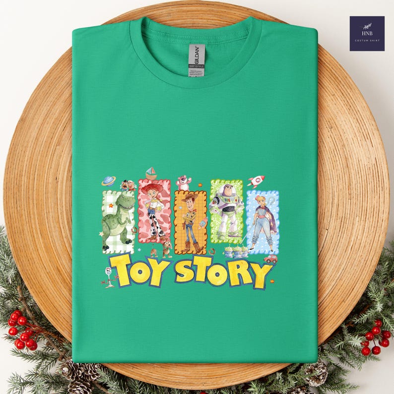 Puede incluir: Una camiseta verde con un gr&aacute;fico colorido de personajes de la pel&iacute;cula animada "Toy Story". El dise&ntilde;o incluye im&aacute;genes de Woody, Buzz Lightyear y otros personajes, con las palabras "Toy Story" en amarillo.