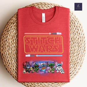 Puede incluir: Camiseta roja con el texto "Stitch Wars" en amarillo y un gr&aacute;fico de personajes de Stitch en un tema de Star Wars.
