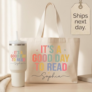 May include: A cream-colored canvas tote bag and a matching cream-colored insulated tumbler with a straw. Both items feature the colorful text "IT'S A GOOD DAY TO READ" and the name "Sophia" in a black script font, accented with small hearts.